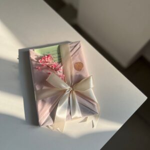 A stylishly wrapped gift with pink flowers and ribbon, perfect for special occasions.